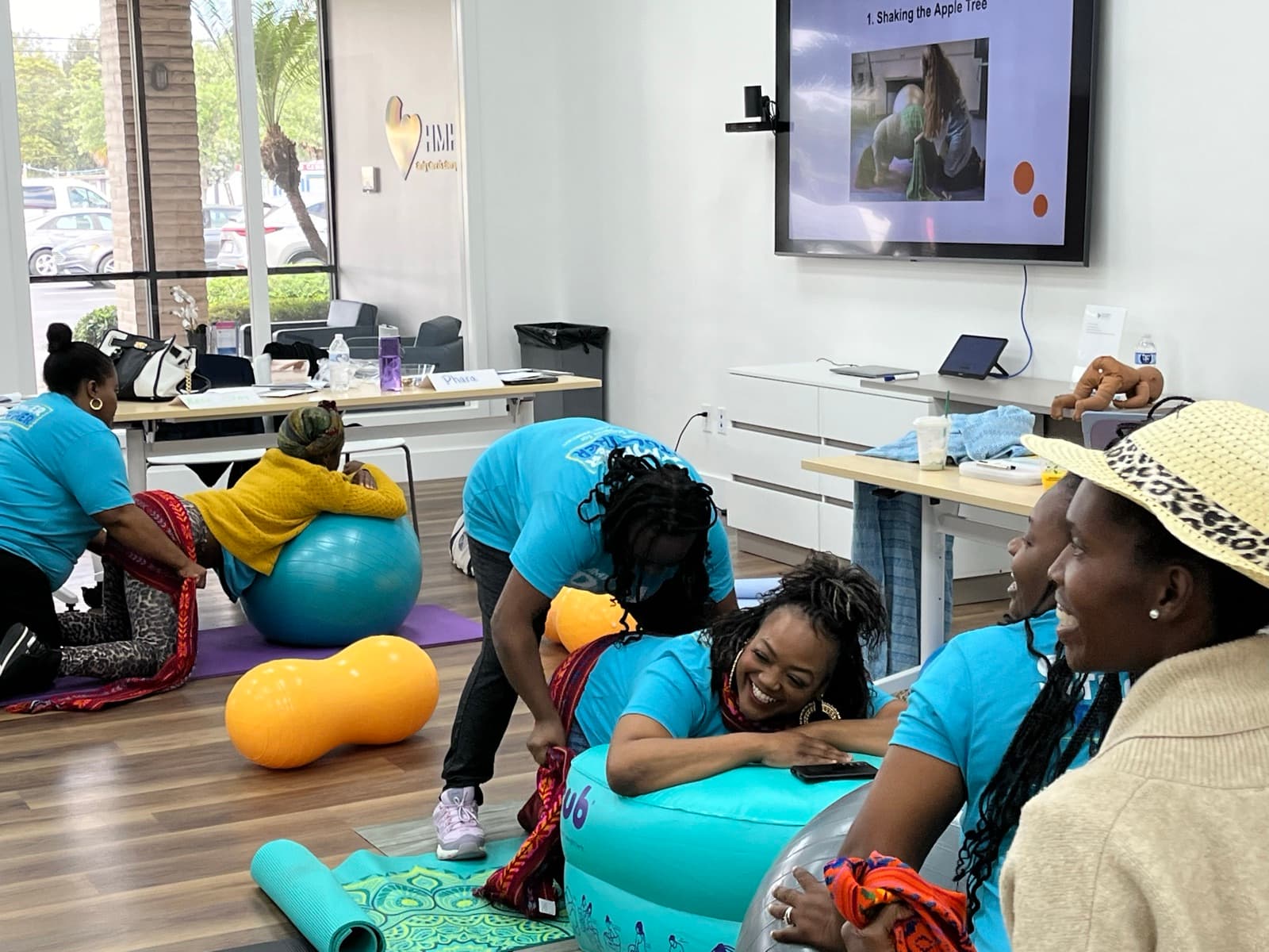 Doula trainees practicing labor-support positions with birthing balls during a training session